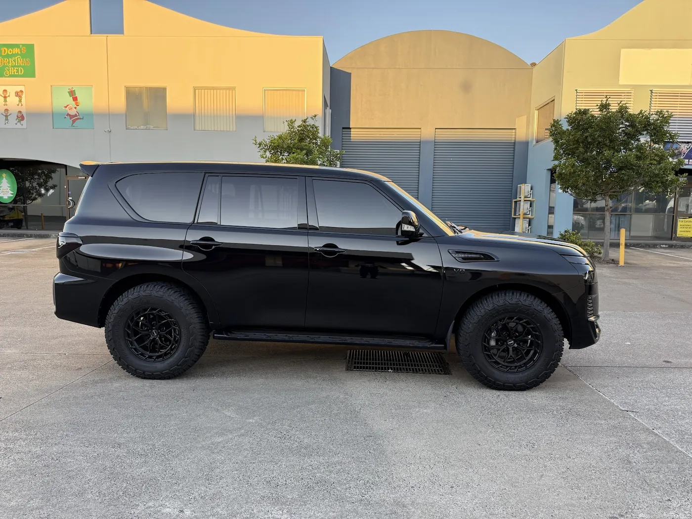 Black SUV parked side-on with uniformly dark tinted side and rear windows.