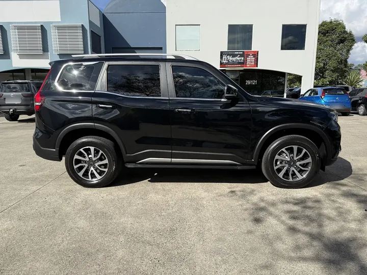 Black SUV parked side-on with dark, evenly tinted side and rear windows.