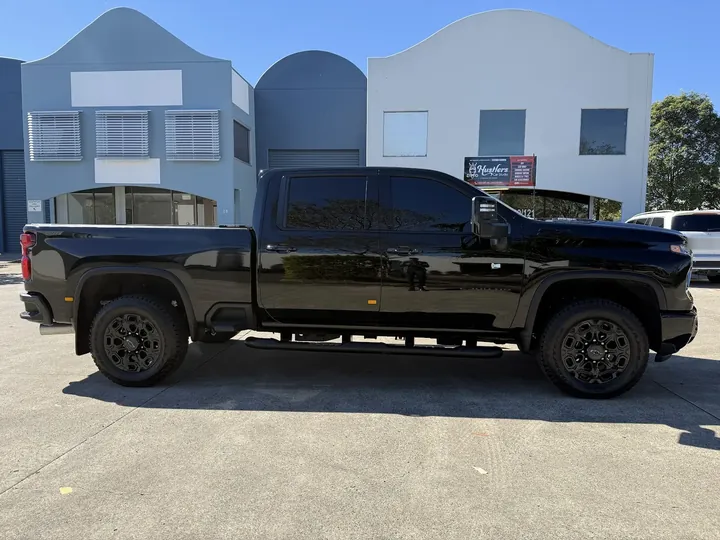 Black dual cab ute parked side-on with dark tinted cabin windows.