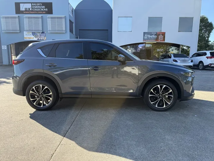 Grey SUV parked side-on in sunlight with tinted windows and multi-spoke alloy wheels.