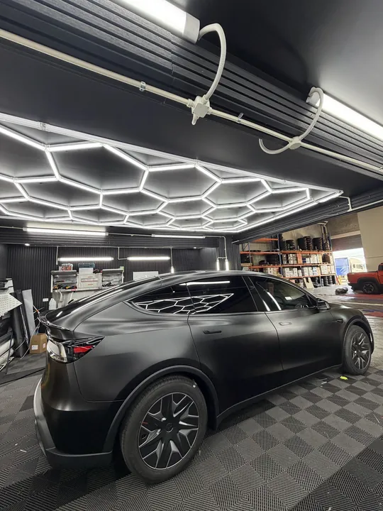 Matte black crossover in the studio bay seen from the rear three-quarter.