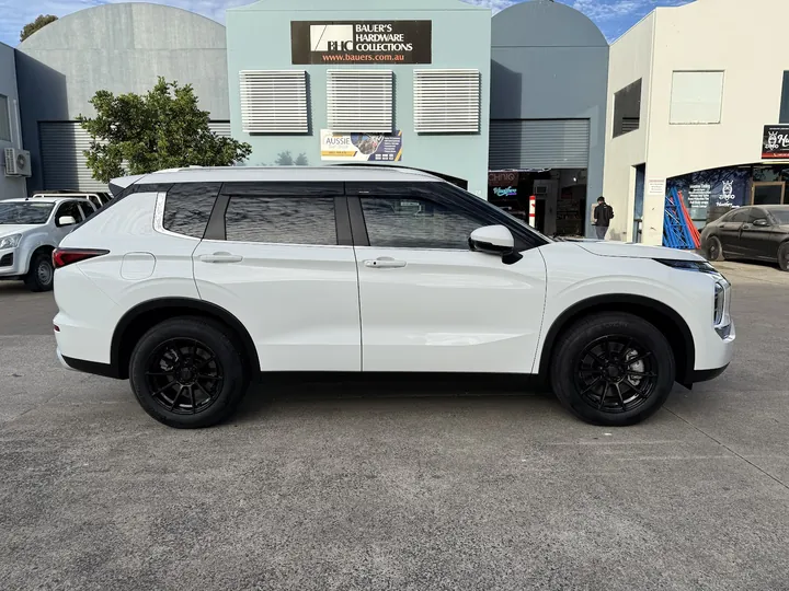 White SUV parked side-on with dark tinted side and rear windows and black wheels.
