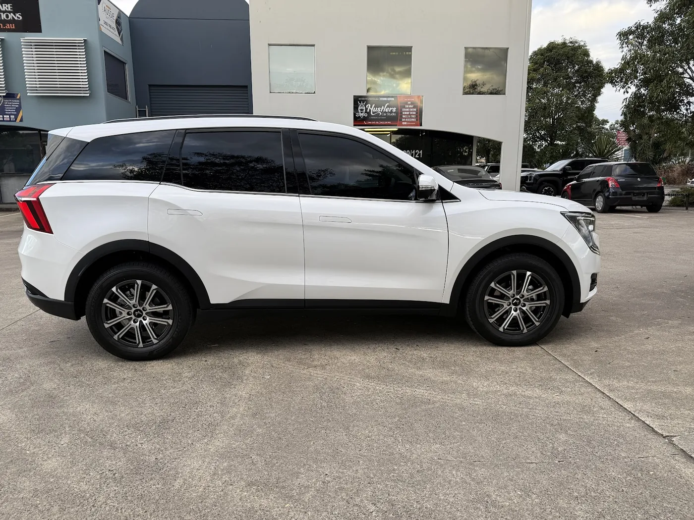 White SUV parked side-on with dark, evenly tinted side and rear windows.