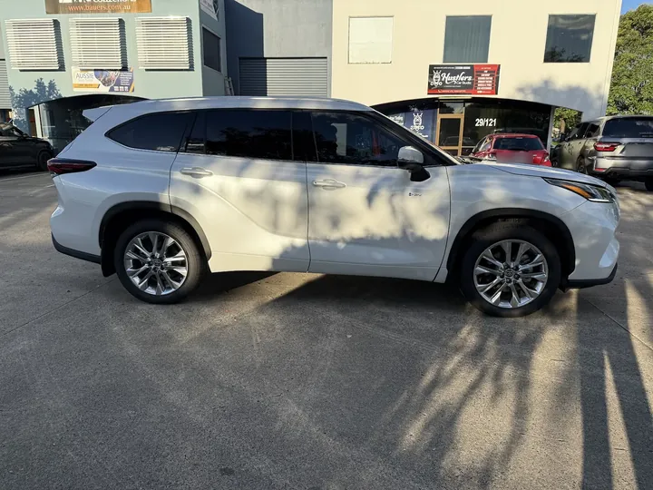 White SUV photographed side-on with dark tinted rear windows and silver alloy wheels.